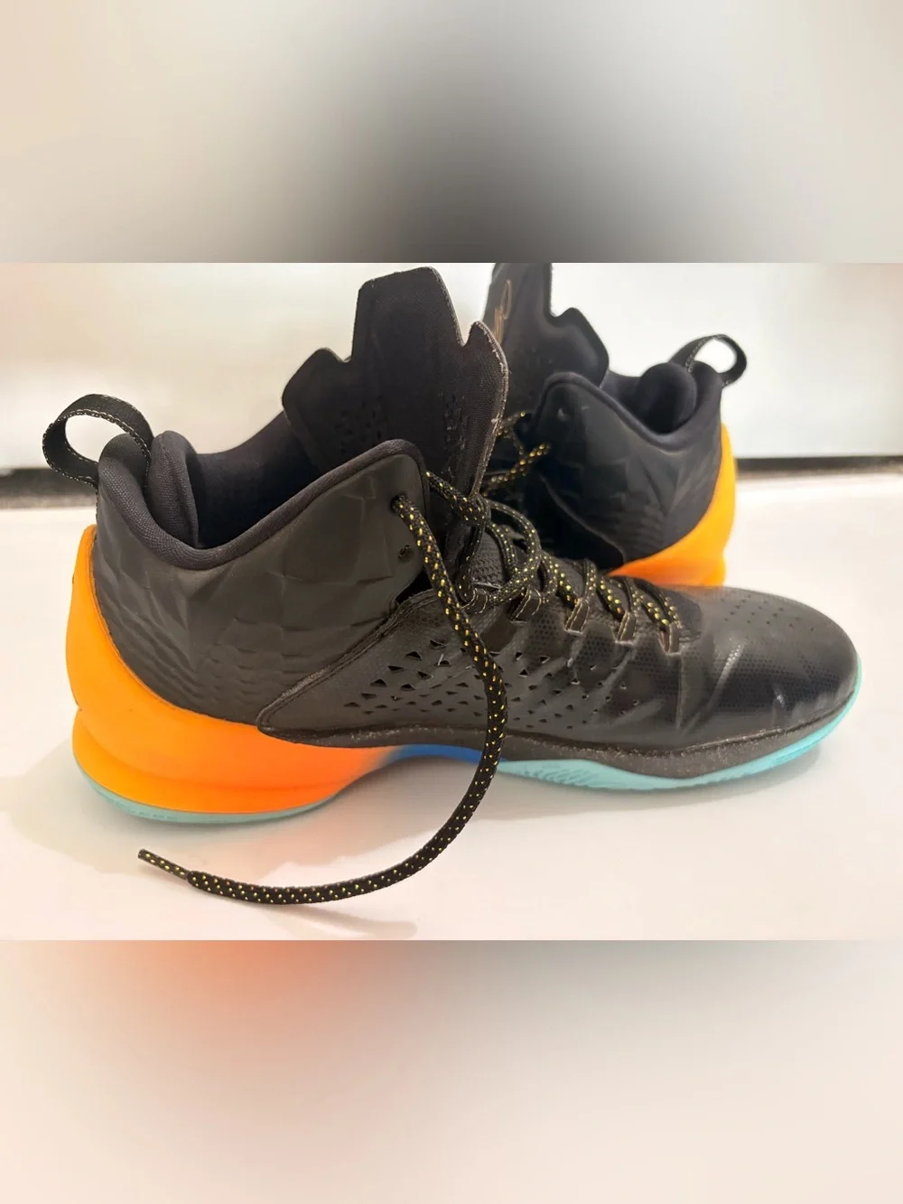 Jordan Melos Mens Black High-Top Sneakers with Orange Heel and Teal Sole